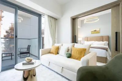 a living room with a white couch and a bed at KeyRock Living - Luxury Apartment with Pool & Gym in Dubai