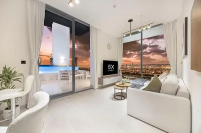 a living room with a white couch and a large window at FiveX Binghatti 2BR with Private Pool in Dubai