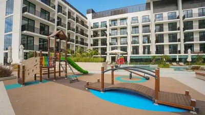 a playground in front of a large building at NEW Studio in JVC with Pool View in Dubai