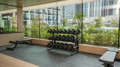 a gym with a bunch of exercise equipment in a building at NEW Studio in JVC with Pool View in Dubai