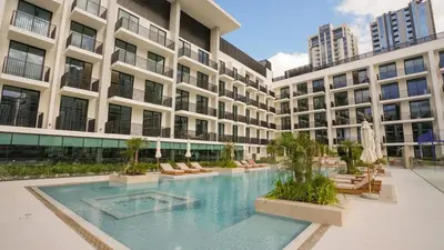 a swimming pool in front of a building at NEW Studio in JVC with Pool View in Dubai