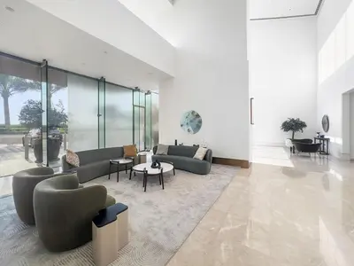 a living room with couches and tables and glass walls at FIRST CLASS 2BR Stylish Downtown Living in Dubai