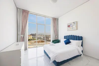 a bedroom with a bed and a large window at FiveX Premium 2BR with Extra Room in Dubai
