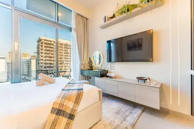 a hotel room with a bed and a large window at Contemporary Studio Apartment with Balcony & Community Views - Azizi Riviera 48, Al Merkadh by Deluxe Holiday Homes in Dubai