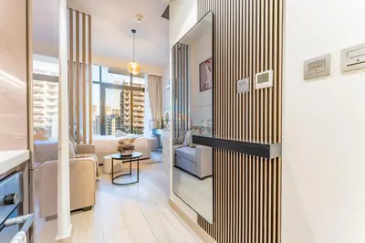 a living room with a sliding door to a living room at Contemporary Studio Apartment with Balcony & Community Views - Azizi Riviera 48, Al Merkadh by Deluxe Holiday Homes in Dubai