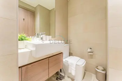 a bathroom with a white sink and a toilet at Contemporary Studio Apartment with Balcony & Community Views - Azizi Riviera 48, Al Merkadh by Deluxe Holiday Homes in Dubai