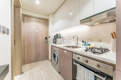 a kitchen with a sink and a washing machine at Contemporary Studio Apartment with Balcony & Community Views - Azizi Riviera 48, Al Merkadh by Deluxe Holiday Homes in Dubai
