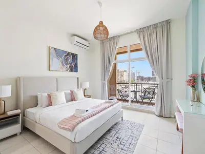 a bedroom with a bed and a large window at Prestige Urban Escape 2BDR In La Fontana in Dubai