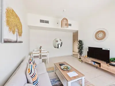 a living room with a couch and a table at Prestige Urban Escape 2BDR In La Fontana in Dubai