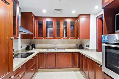 a kitchen with wooden cabinets and a sink at Silkhaus Private Garden in Old Town Zanzebeel Bldg in Dubai