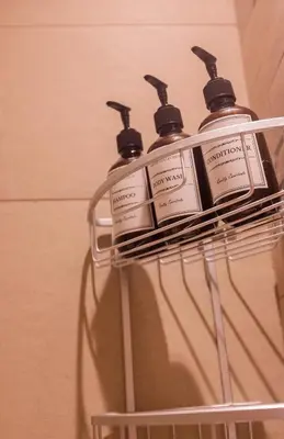 a group of four bottles of soap on a rack at Spacious Comfortable One Bed Downtown Dubai in Dubai