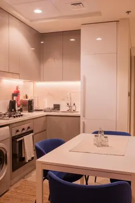 a kitchen with a table and blue chairs at Spacious Comfortable One Bed Downtown Dubai in Dubai