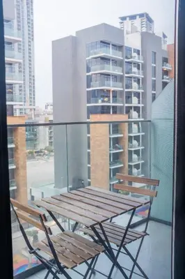 a wooden table and two chairs on a balcony at Spacious Comfortable One Bed Downtown Dubai in Dubai