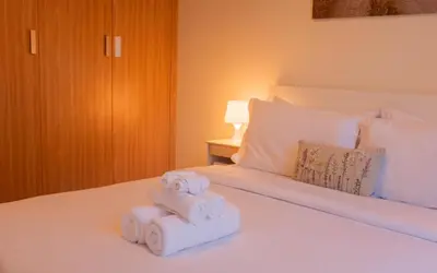 two rolls of towels sitting on top of a bed at Spacious Comfortable One Bed Downtown Dubai in Dubai