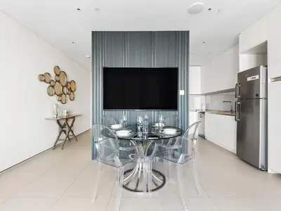 a kitchen with a glass table with a television on the wall at Timeless Elegance 1BR Address Beach JBR in Dubai