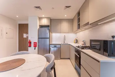 a kitchen with stainless steel appliances and a table at HAVN - 1 bedroom in Madinat Jumeirah Living in Dubai