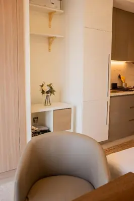 a living room with a chair and a kitchen at Snug Modern Downtown Dubai Studio in Dubai