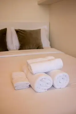 a pile of towels sitting on top of a bed at Snug Modern Downtown Dubai Studio in Dubai