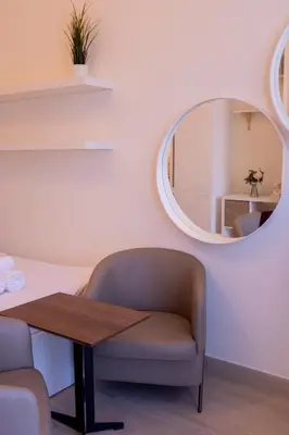 a table and a chair in a room with a mirror at Snug Modern Downtown Dubai Studio in Dubai