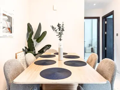a dining room table with chairs and a vase on it at Jewelz by Danube, Arjan, Al Barsha - Onelink in Dubai