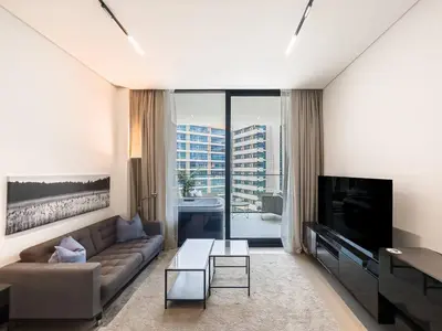 a living room with a couch and a tv at Modern Studio with Private Jacuzzi in Dubai