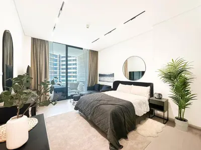 a white bedroom with a bed and a mirror at Modern Studio with Private Jacuzzi in Dubai