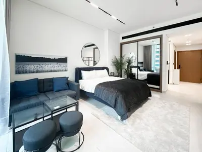 a bedroom with a bed and a couch at Modern Studio with Private Jacuzzi in Dubai
