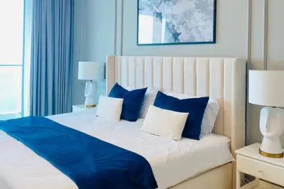 a bedroom with a bed with blue and white pillows at ADDRESS BEACH RESORT Residence Luxury Sea and Palm View DXB AIRPORT VIP Shuttle option for 6pax in Dubai
