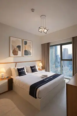 a bedroom with a large bed and a large window at Rentico l Ultra Luxury 2BR Burj Khalifa & Fountain in Dubai