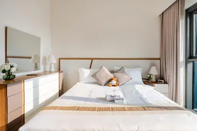 a bedroom with a large white bed and a mirror at Rentico l Ultra Luxury 2BR Burj Khalifa & Fountain in Dubai