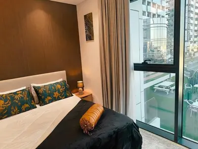 a bedroom with a bed and a large window at Jumeirah Village Triangle in Dubai