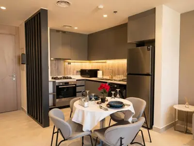 a kitchen with a table and chairs and a refrigerator at Jumeirah Village Triangle in Dubai