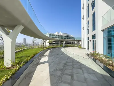 a walkway next to a building with a cruise ship at Luxury 1BR - Miracle Garden View - Skyz in Arjan in Dubai