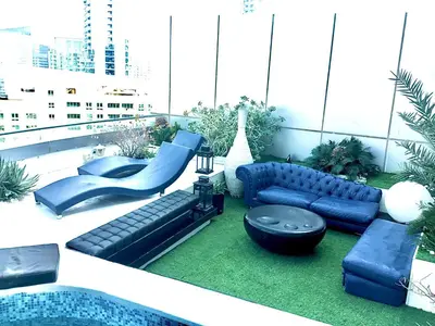 a rooftop patio with blue furniture and a pool at Full marina view private pool vip adult only no halal in Dubai