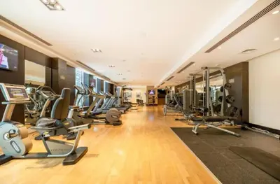 a gym with a bunch of treadmills and machines at FIRST CLASS 1BR Elegance Near Burj Khalifa in Dubai