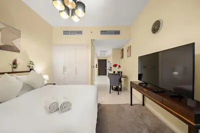 a living room with a large flat screen tv at FIRST CLASS Studio Cozy Luxe Retreat in Dubai