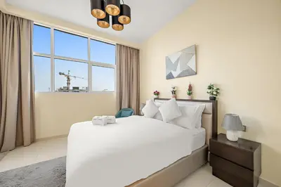 a bedroom with a large bed and a large window at FIRST CLASS Studio Cozy Luxe Retreat in Dubai