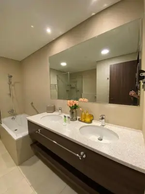 a bathroom with a sink and a large mirror at Prestige Avani Residence 2BR with Golf Course View in Dubai
