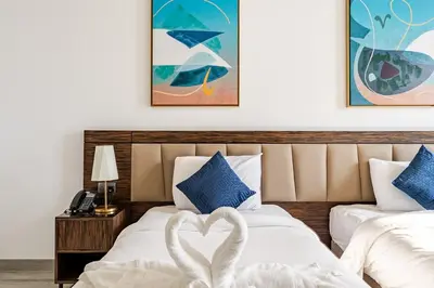 a bedroom with two beds with a heart made out at Prestige Avani Residence 2BR with Golf Course View in Dubai