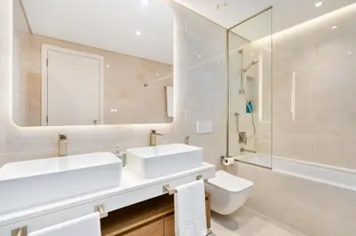 a bathroom with a sink and a toilet and a mirror at Brand New Luxury Family Friendly 3 beds Near Burj AlArab Ultimate Stay in Dubai