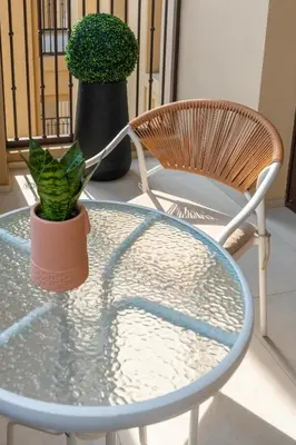 a glass table with a chair and a plant on it at Brand New Luxury Family Friendly 3 beds Near Burj AlArab Ultimate Stay in Dubai