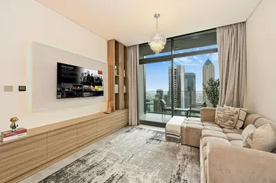 a living room with a couch and a large window at Curated High Floor 1BR-Sofa Bed Water View Peninsula 1 in Dubai