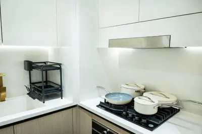 a kitchen with two pots and pans on a stove at Binghatti Aurora, JVC Dubai - Unique Round Bed Experience with pool view in Dubai