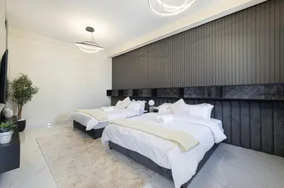 two beds in a large room with a wall at Beachfront Spacious Apartment with Sea & Palm Views in Dubai