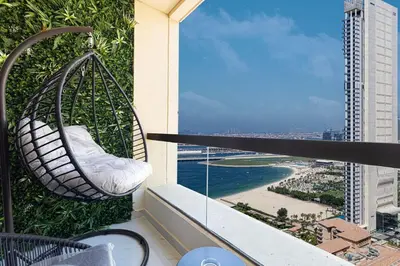 a hanging hammock on the balcony of a building at Beachfront Spacious Apartment with Sea & Palm Views in Dubai