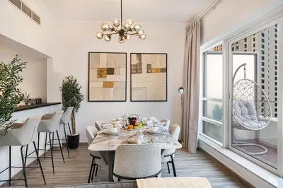 a dining room with a table and chairs and a chandelier at Luxury Duplex Penthouse with Stunning Marina Views in Dubai