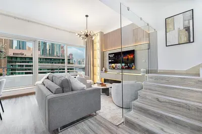 a living room with a couch and a fireplace at Luxury Duplex Penthouse with Stunning Marina Views in Dubai