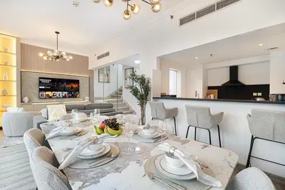 a dining room and living room with a table and chairs at Luxury Duplex Penthouse with Stunning Marina Views in Dubai