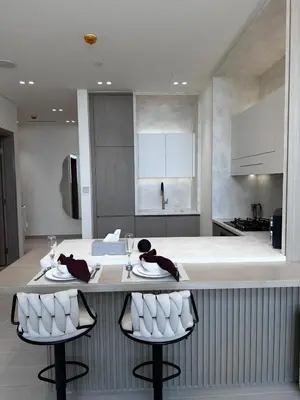 a kitchen with a large island with two stools at Modern1BR Binghatti Phantom Private pool JVC in Dubai