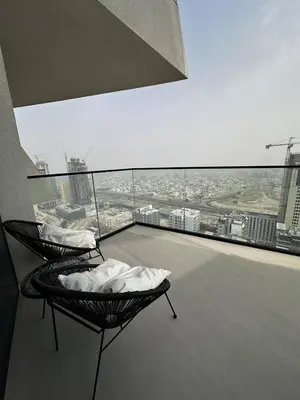 a balcony with two chairs and a view of a city at Modern1BR Binghatti Phantom Private pool JVC in Dubai